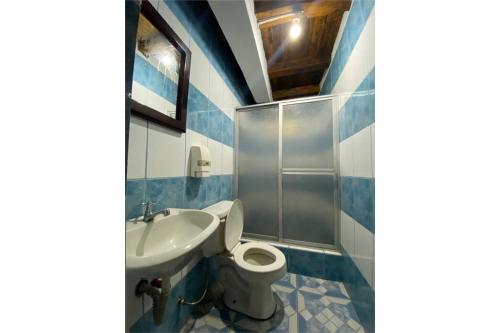 a bathroom with a toilet and a sink at Rumipaxi Lodge in Latacunga