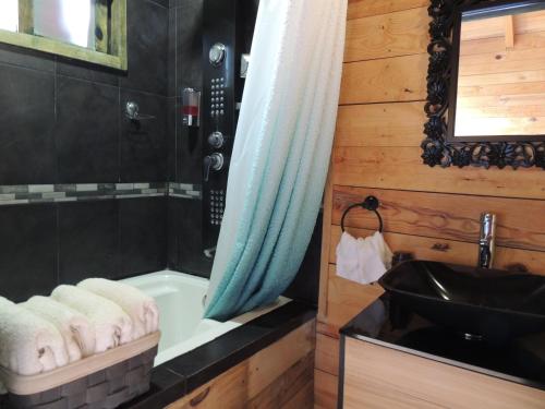 a bathroom with a bath tub and a sink at Cabañas Big Mountain in Bernal