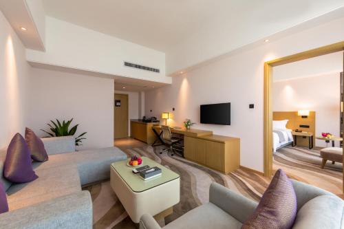 a living room with a couch and a table in a room at 佛山金美域林禧酒店 in Foshan