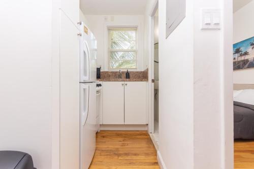 a small kitchen with white cabinets and a window at Fort Lauderdale Studio - 5 minutes Las Olas Beach in Fort Lauderdale