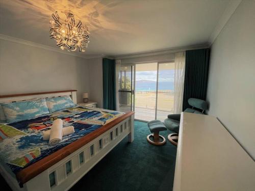 a bedroom with a bed with a view of the ocean at West Beach House in Esperance