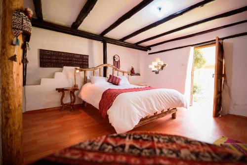 a bedroom with a large bed in a room at Rumi Lodge Pisac in Pisac
