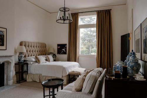 a bedroom with two beds and a couch and a window at Moss Manor in Moss Vale