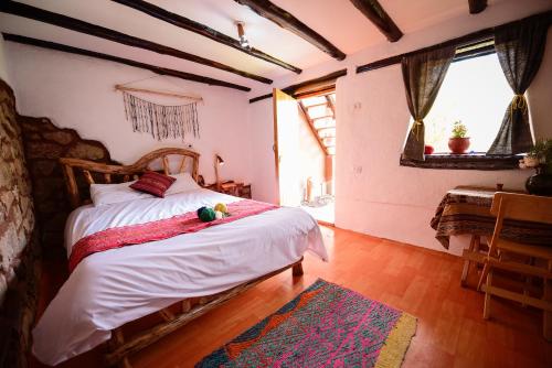a bedroom with a large bed with a wooden headboard at Rumi Lodge Pisac in Pisac