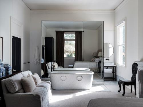 a living room with a large mirror and a tub at Moss Manor in Moss Vale