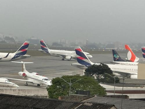 un grupo de aviones estacionados en la pista de aterrizaje en un aeropuerto en Audaar Tech Suítes - Aeroporto de Congonhas en São Paulo