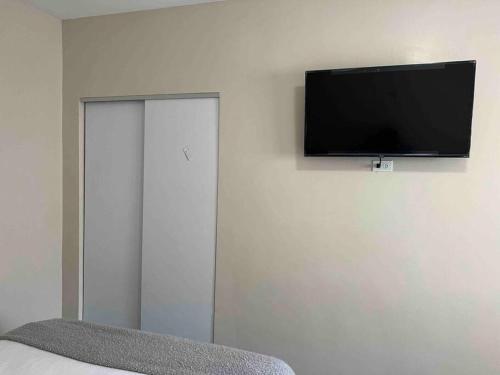 a flat screen tv hanging on a white wall at Suites González, Suite 2 in Ciudad Juárez