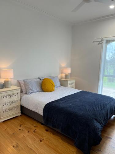a bedroom with a bed with a yellow pillow on it at King Edi Cottage in Edi