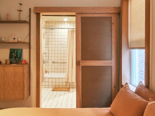 a bedroom with a door leading to a bathroom at guesthouse by good neighbor in Baltimore