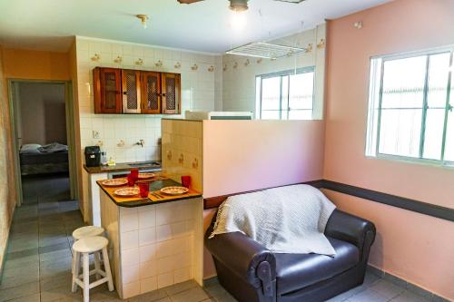 uma cozinha com um sofá e uma mesa num quarto em Apartamentos Incríveis Primeira Quadra Mar WiFi em Ubatuba