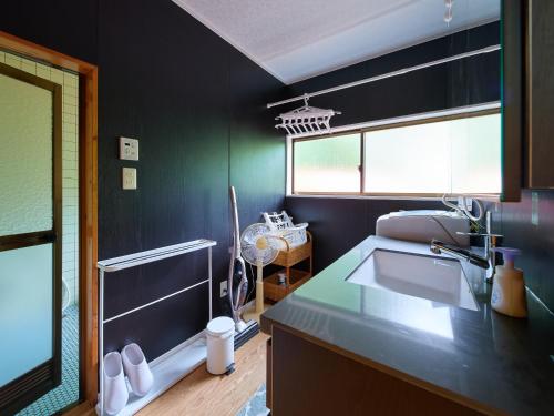 uma cozinha com paredes pretas, um lavatório e uma janela em 那須 - Nasu 369 MOMURA Cottage - ペット可 em Nasushiobara