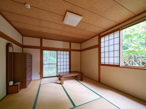 ein leeres Zimmer mit einem Tisch und zwei Fenstern in der Unterkunft 那須 - Nasu 369 MOMURA Cottage - ペット可 in Nasushiobara