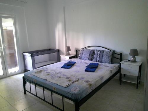 1 dormitorio con 1 cama con 2 toallas azules en Konstantinos Apartmend Halkidiki, en Sozopoli