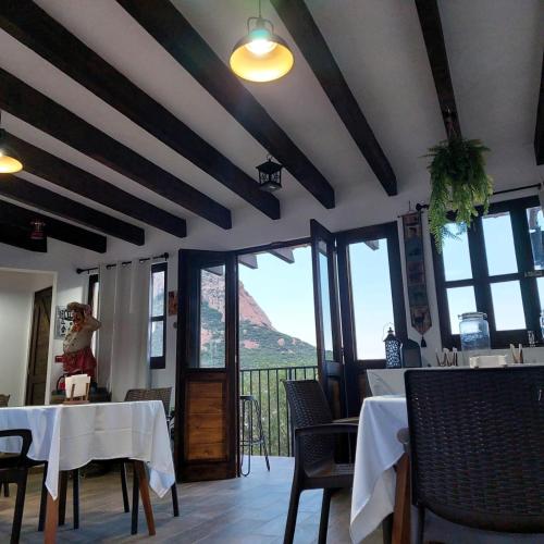 a restaurant with tables and chairs with a view of a mountain at Cabañas Big Mountain in Bernal