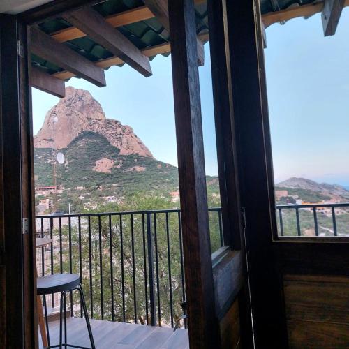 a room with a balcony with a view of a mountain at Cabañas Big Mountain in Bernal
