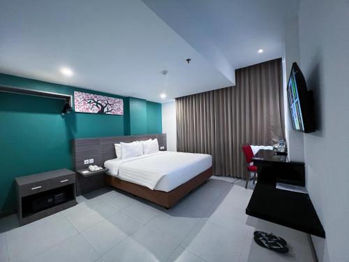 a bedroom with a bed and a television in it at Ayani Hotel Banda Aceh in Banda Aceh