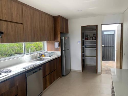 a kitchen with a sink and a refrigerator at Hermosa casa de campo en ambiente tranquilo. in Rionegro