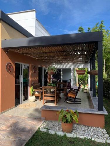 a patio with a table and chairs under a pergola at Hermosa casa de campo en ambiente tranquilo. in Rionegro