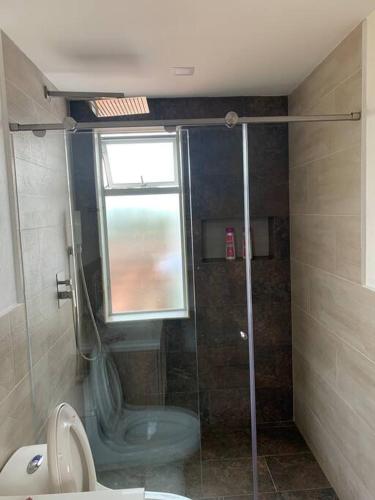 a bathroom with a shower with a toilet and a window at Hermosa casa de campo en ambiente tranquilo. in Rionegro