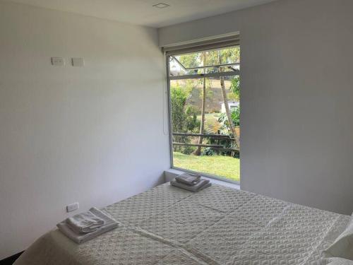 a bedroom with a bed and a window at Hermosa casa de campo en ambiente tranquilo. in Rionegro