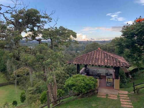 a gazebo with a view of a field at Hermosa casa de campo en ambiente tranquilo. in Rionegro
