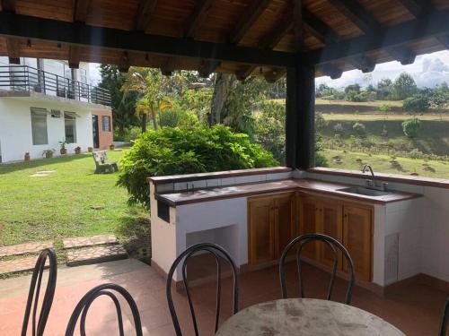 an outdoor kitchen with a table and chairs on a patio at Hermosa casa de campo en ambiente tranquilo. in Rionegro