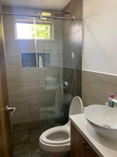 a bathroom with a toilet and a glass shower at Hermosa casa de campo en ambiente tranquilo. in Rionegro