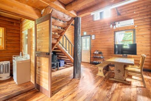 a wooden cabin with a desk with a television in it at COTTAGE SaY in Nasushiobara