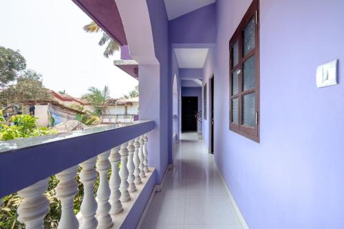 a hallway of a house with blue walls and a balcony at Ps Guest House Near Calangute Beach in Calangute