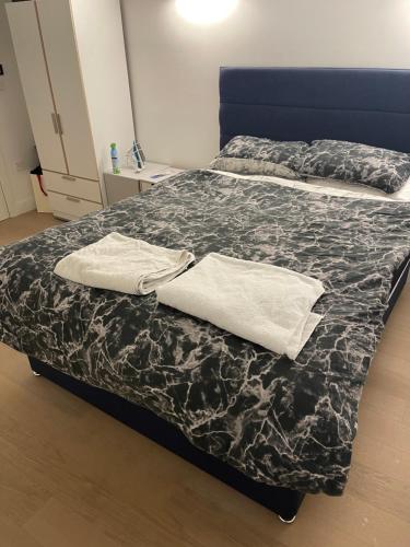 Una cama con dos toallas blancas encima. en Lovely bright, modern 1-bed apartment, en Londres