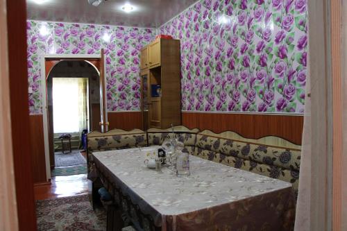 a dining room with a table and purple wallpaper at Guest House on Derbisheva in Karakol