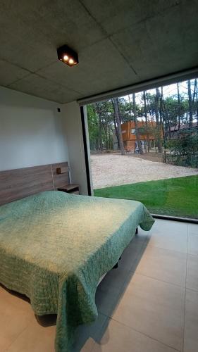 a bedroom with a bed and a large window at Lucero in Mar Azul