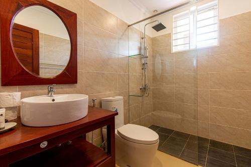W łazience znajduje się umywalka, toaleta i lustro. w obiekcie Residence 22 w Siem Reap