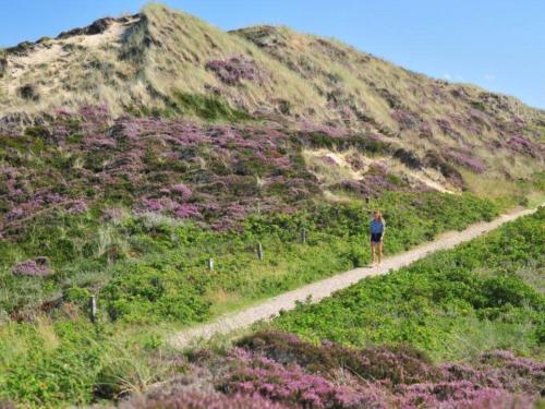 a woman walking down a dirt path on a hill at Spatzennest in Kampen