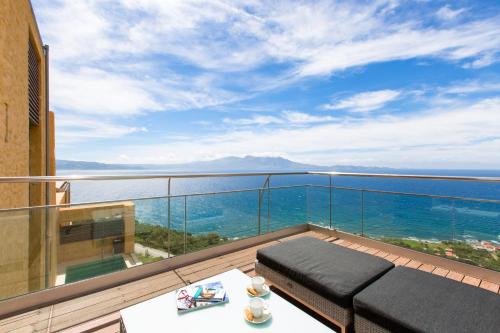 a balcony with a view of the ocean at Eleni's Serenity - Discovering Sapphire Harmonies in Ravdhoúkha