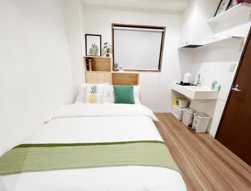 a small bedroom with two beds and a mirror at dandelion house in Tokyo