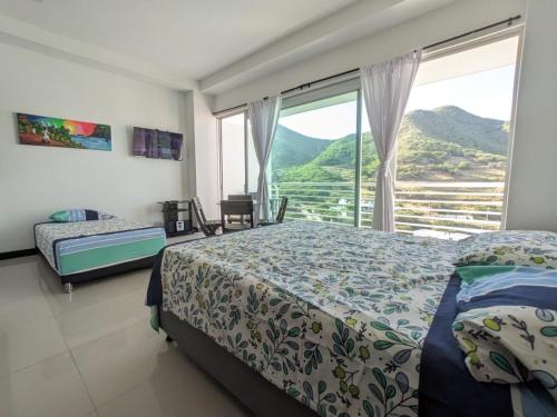 a bedroom with a bed and a large window at Espectacular Apartamento-Loft, en el Rodadero. in Gaira