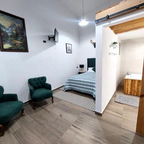 a bedroom with a bed and two chairs at Cabañas Big Mountain in Bernal