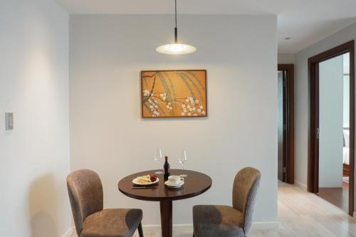 a dining room with a table and chairs at Signature by M Village Lê Thánh Tôn in Ho Chi Minh City