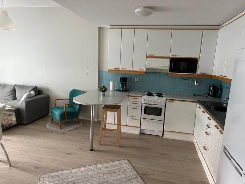 a small kitchen with a table and a couch at Utopia 1BR and sauna in Tornio