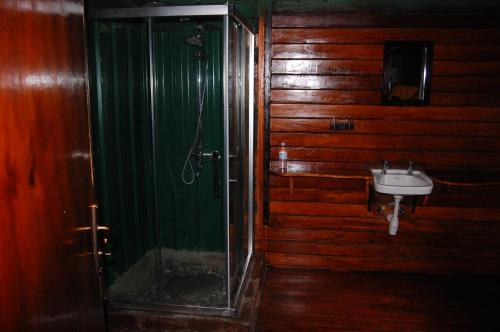 a bathroom with a glass shower and a sink at Snow Heights Lodges in Kasese
