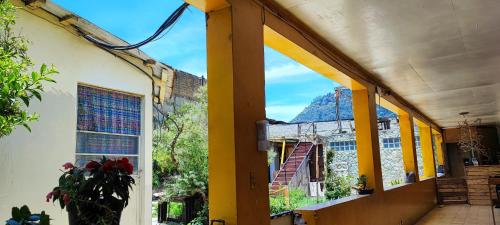 um edifício com colunas amarelas e uma janela em Casa I`X em Quetzaltenango