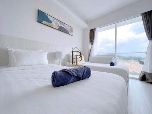 2 camas en una habitación de hotel con ventana grande en Paradise Perch Tanjung Aru Inifnity Pool 2BR, en Kota Kinabalu