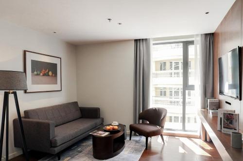 a living room with a couch and a chair at Signature by M Village Lê Thánh Tôn in Ho Chi Minh City