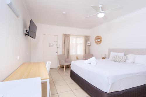 een hotelkamer met 2 bedden, een tafel en een bureau bij The Marco Polo in Mackay