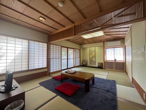 Habitación con mesa en una habitación con ventanas en フクロウの御宿　新館, en Fuefuki