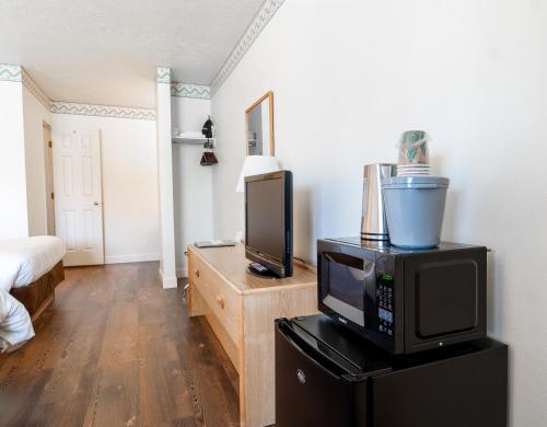 a living room with a television and a microwave at Motel Torrey in Torrey