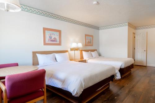 a hotel room with two beds and a chair at Motel Torrey in Torrey