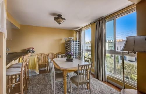 a dining room with a table and chairs and a large window at West Hollywood-Beverly Hills Condo-Room For Rent in Los Angeles