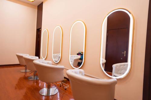 a row of mirrors in a salon with white chairs at ST Vegas Hotel in Ban Nong-Heo